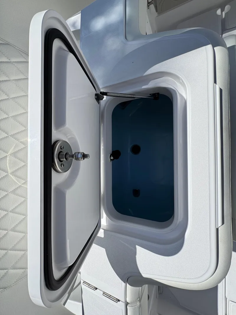 Slide: The Image of Open storage compartment on 2025 Jupiter 380LS boat, featuring a sleek white design. - 24