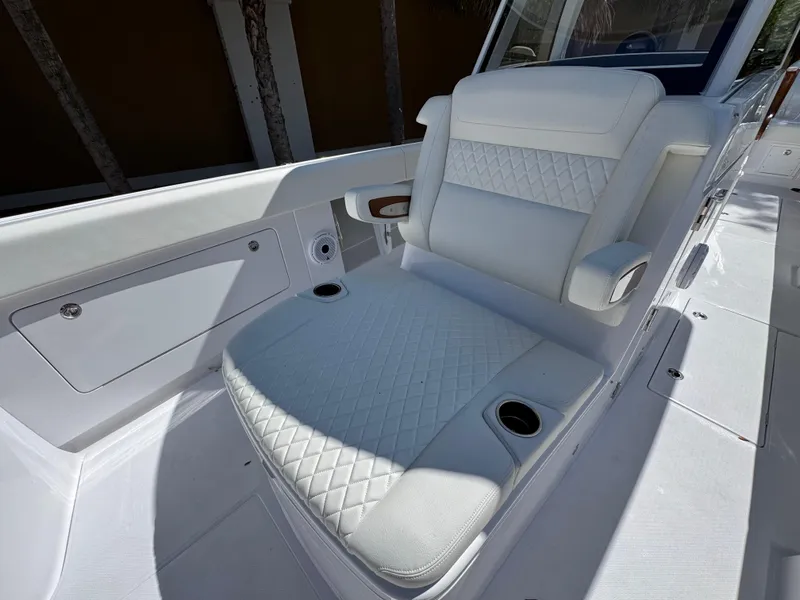 Slide: The Image of Luxurious seating on 2025 Jupiter 380LS boat with quilted upholstery and cup holders. - 5