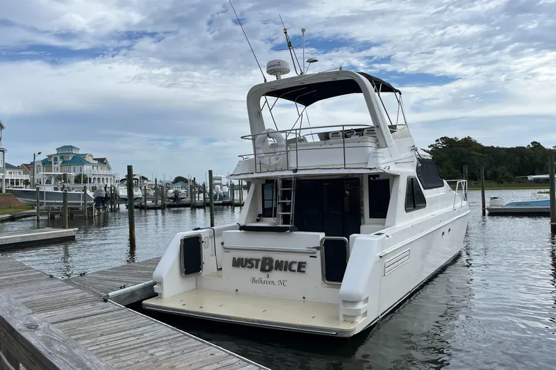 Slide: The Image of Custom Sports Catamaran 44, 2001 model, docked at marina with scenic waterfront view. - 4