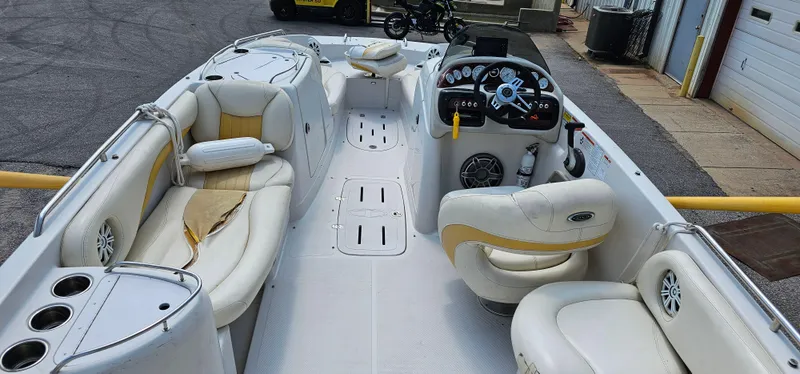 Slide: The Image of 2011 Tahoe 225 boat interior with white and yellow seating, steering console, and cup holders. - 10