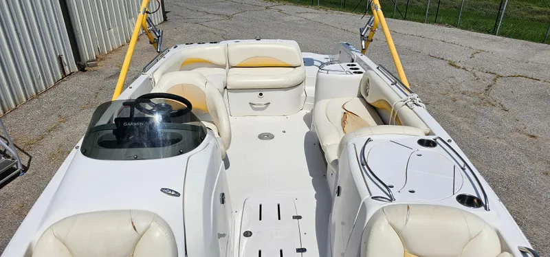 Slide: The Image of 2011 Tahoe 225 boat interior with white and yellow seating, steering wheel, and Garmin device. - 4