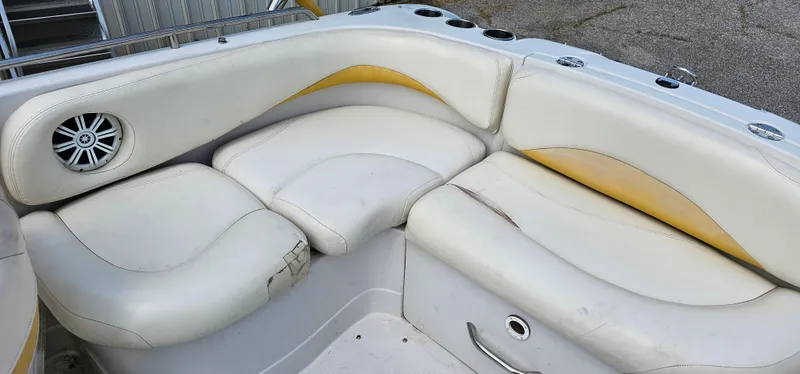 Slide: The Image of 2011 Tahoe 225 boat interior with white and yellow seating, featuring a speaker and cup holders. - 8