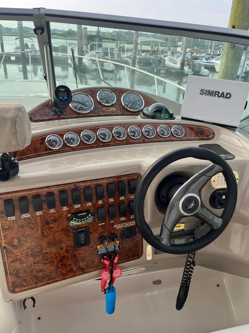 Slide: The Image of 2003 Maxum 3300 SCR boat dashboard with steering wheel and Simrad navigation system. - 13