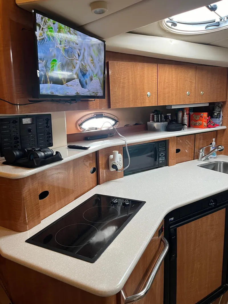 Slide: The Image of 2003 Maxum 3300 SCR yacht interior with modern kitchen, TV, and appliances. - 14