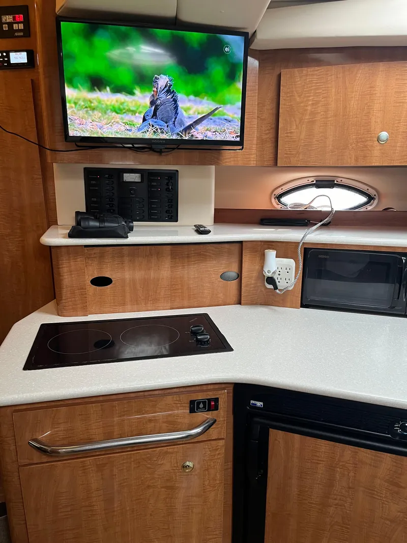 Slide: The Image of 2003 Maxum 3300 SCR yacht interior with kitchenette, TV, and modern appliances. - 15