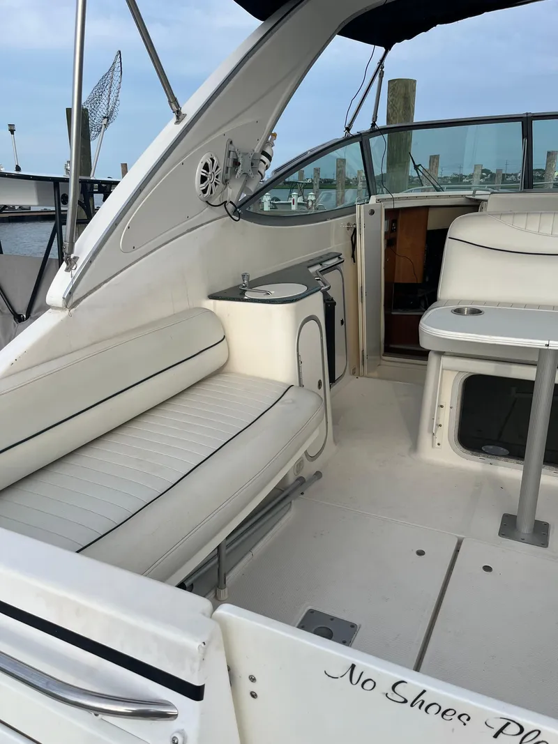 Slide: The Image of 2003 Maxum 3300 SCR boat interior with white seating and table, docked at marina. - 17
