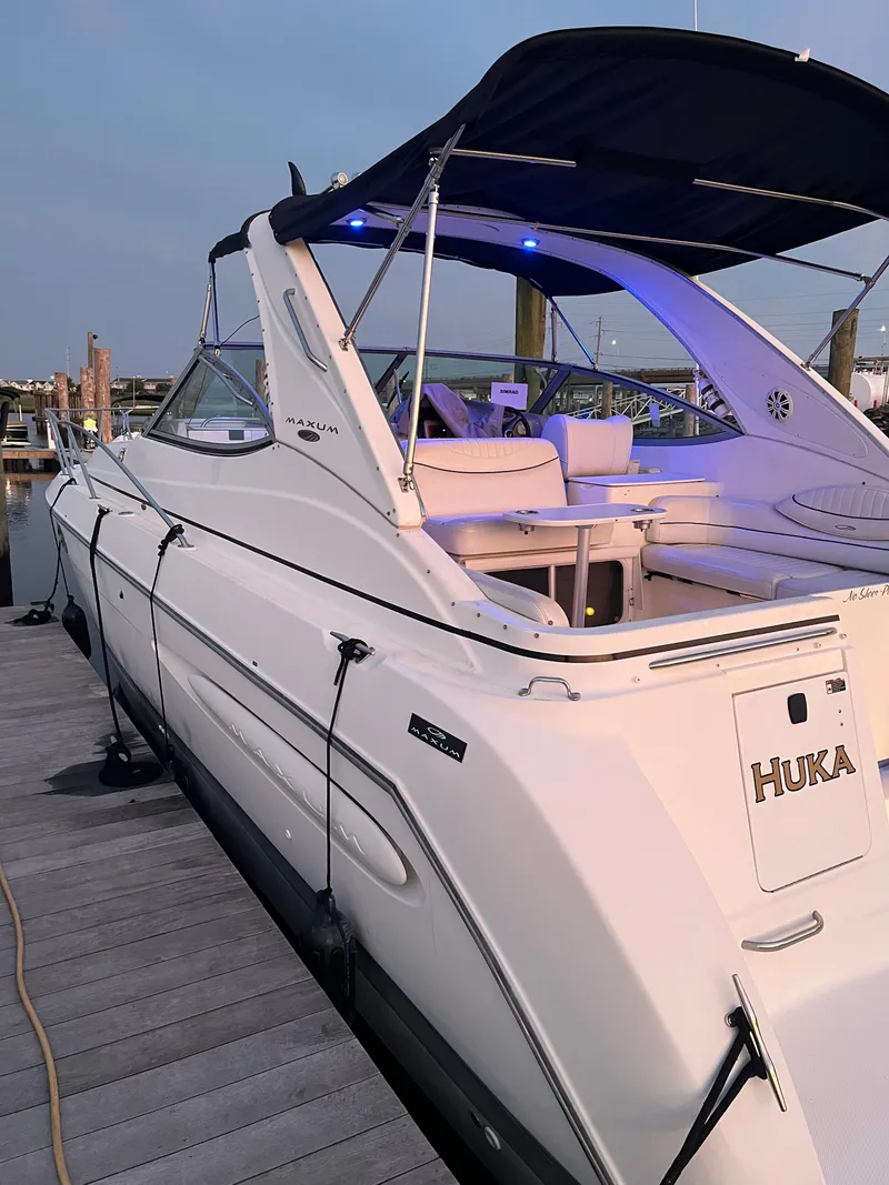 Slide: The Image of 2003 Maxum 3300 SCR yacht docked, featuring sleek design and spacious seating area. - 2