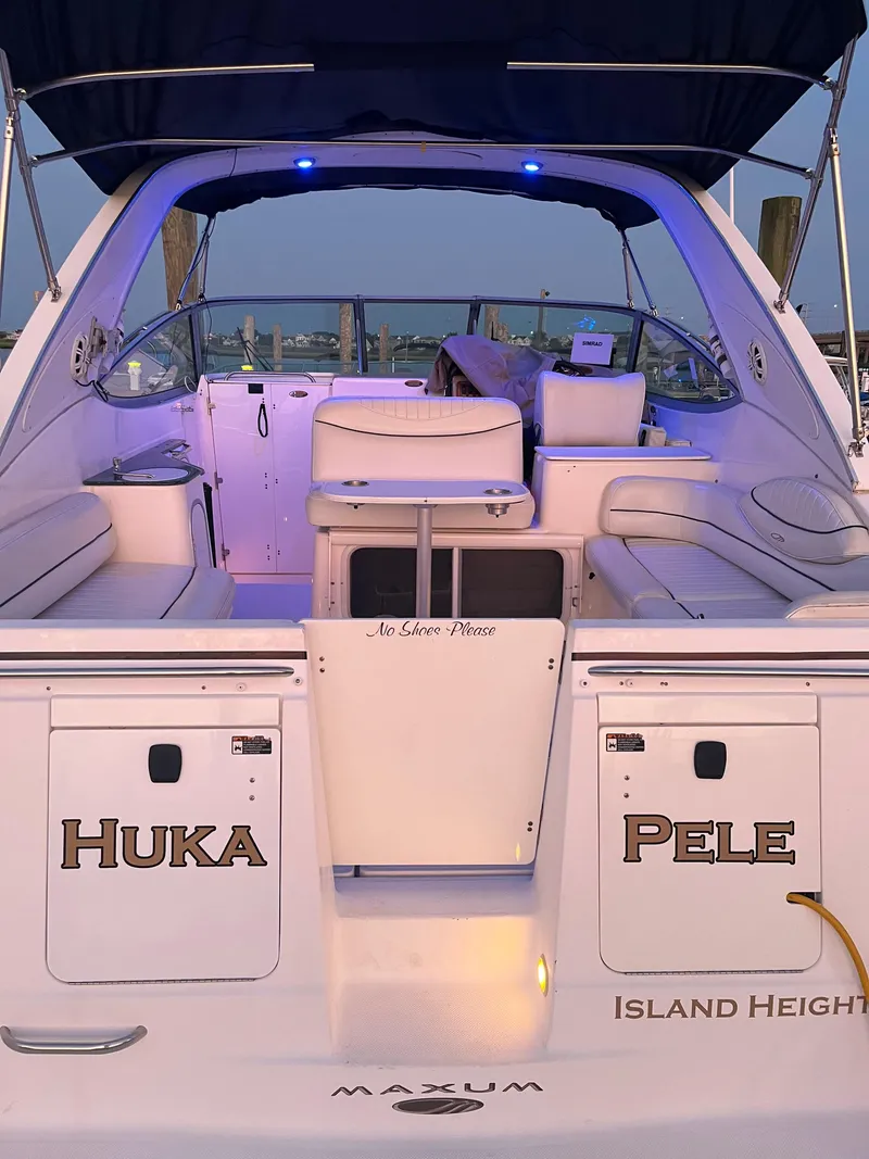 Slide: The Image of 2003 Maxum 3300 SCR boat with illuminated seating area and "Huka Pele" text. - 5