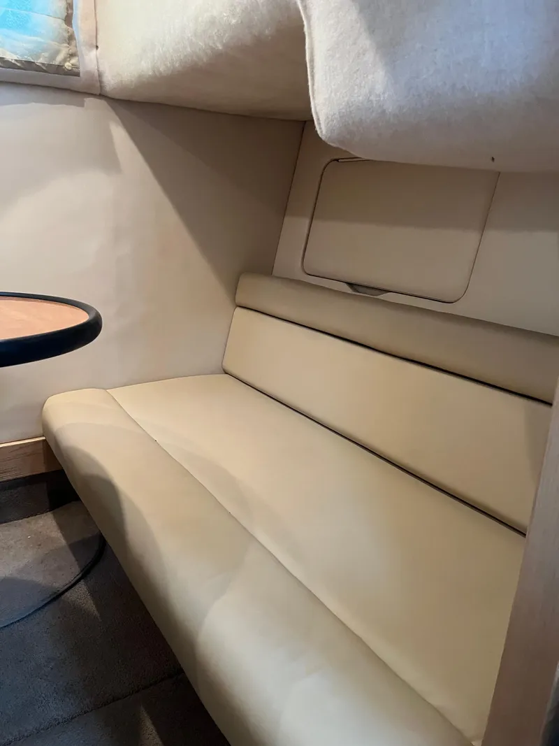 Slide: The Image of 2003 Maxum 3300 SCR cabin interior with beige seating and table. - 6