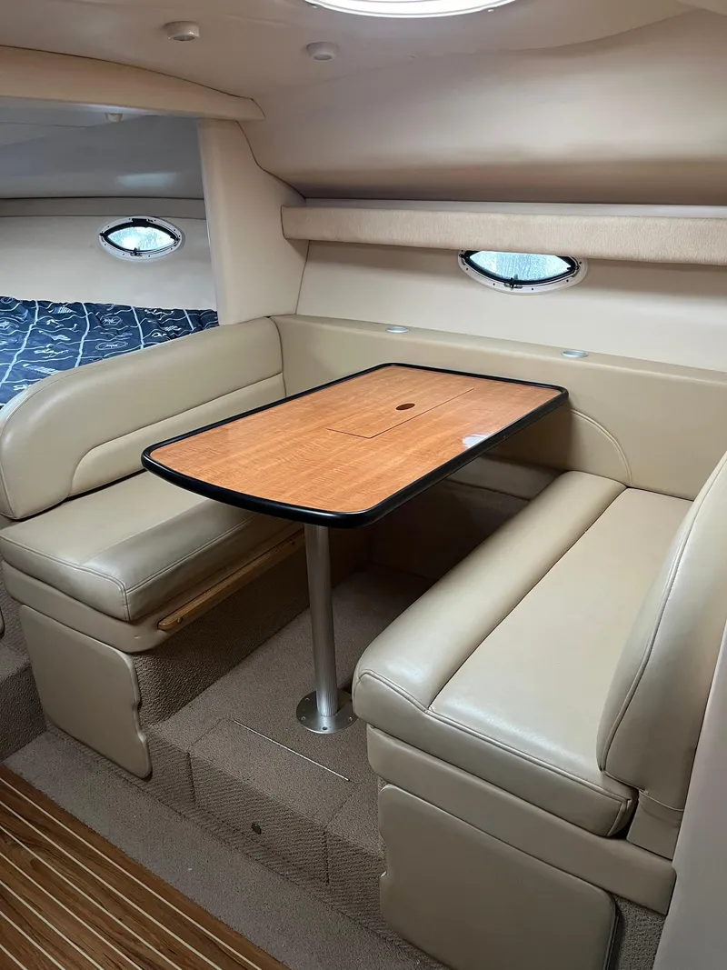 Slide: The Image of 2003 Maxum 3300 SCR cabin interior with beige seating and wooden table. - 8