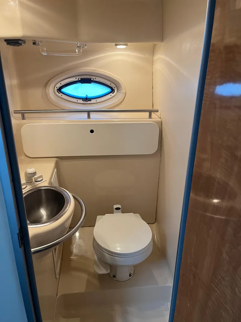 Slide: The Image of Compact bathroom in 2003 Maxum 3300 SCR boat with sink, toilet, and porthole window. - 9