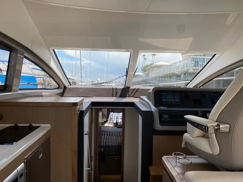 Slide: The Image of Interior view of 2018 Sea Ray 400 Fly yacht, featuring helm and cabin area. - 14