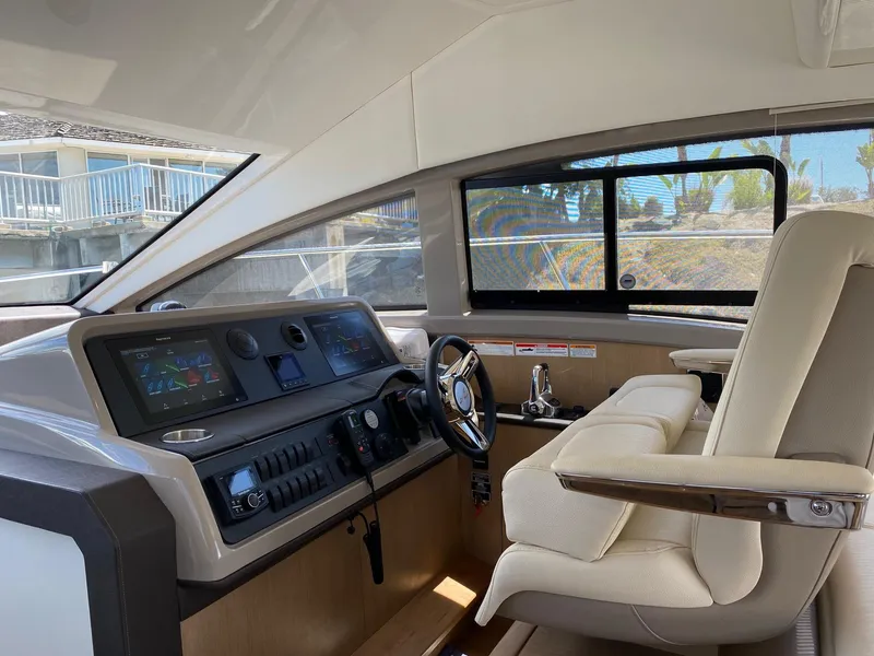 Slide: The Image of Interior helm of 2018 Sea Ray 400 Fly yacht with modern controls and plush seating. - 15