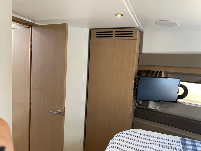 Slide: The Image of Interior of 2018 Sea Ray 400 Fly yacht cabin with TV and wooden furnishings. - 28