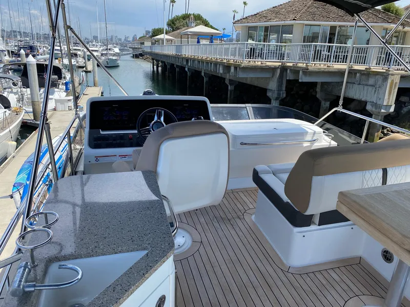 Slide: The Image of Flybridge of 2018 Sea Ray 400 Fly yacht docked at marina, featuring helm and seating area. - 35
