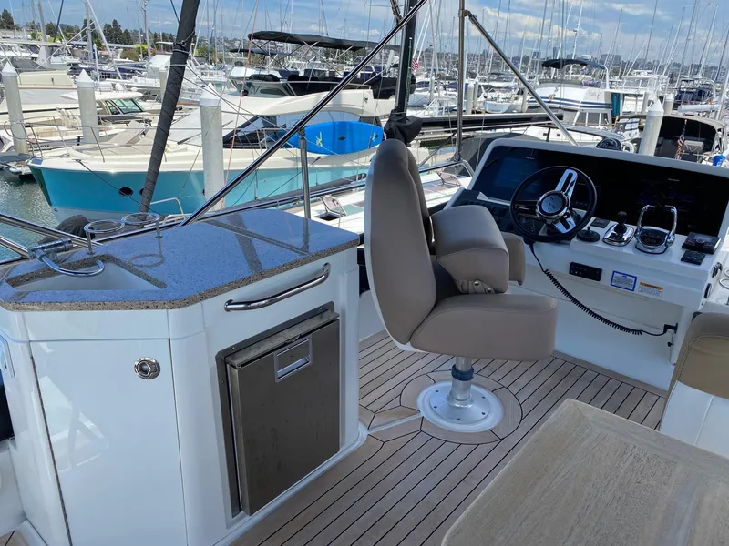 Slide: The Image of Flybridge of 2018 Sea Ray 400 Fly yacht with helm station and marina view. - 36