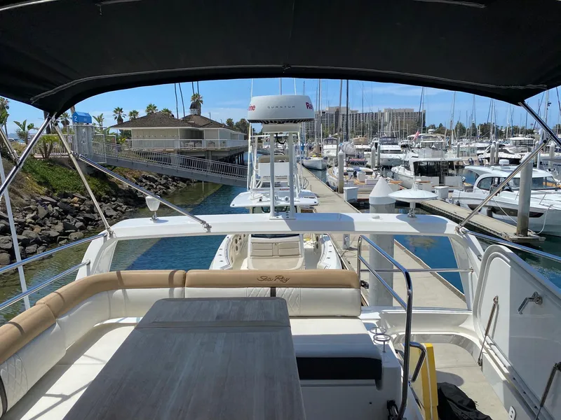 Slide: The Image of 2018 Sea Ray 400 Fly yacht docked at marina, featuring spacious deck and seating area. - 41