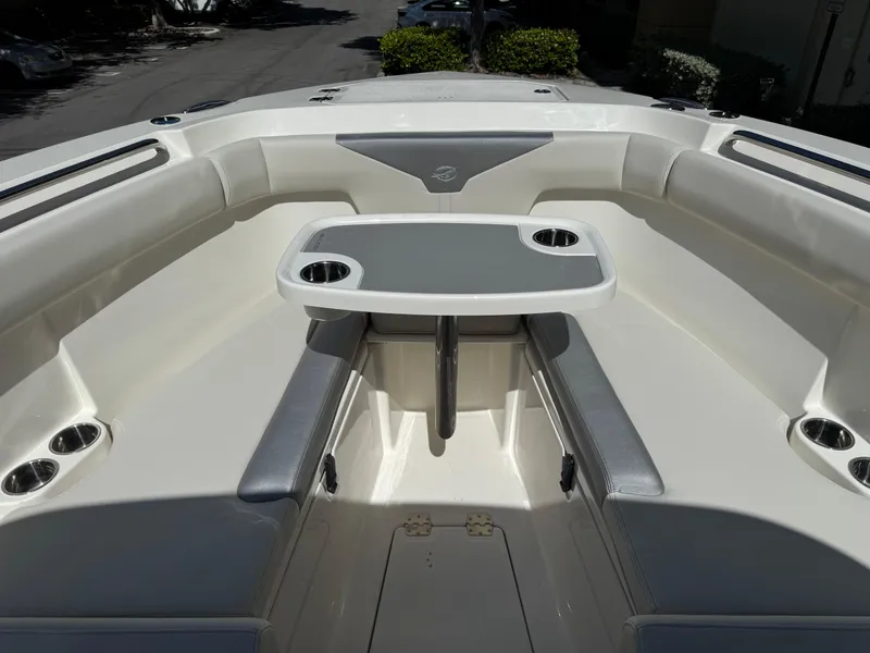 Slide: The Image of 2026 Sailfish 312 CC boat interior with seating and table, featuring cup holders. - 12
