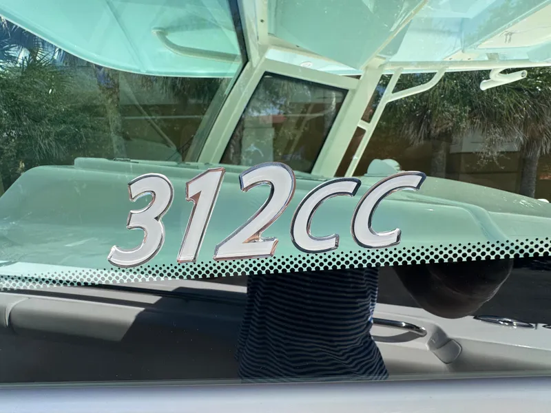Slide: The Image of 2026 Sailfish 312 CC boat model emblem on glass surface. - 13