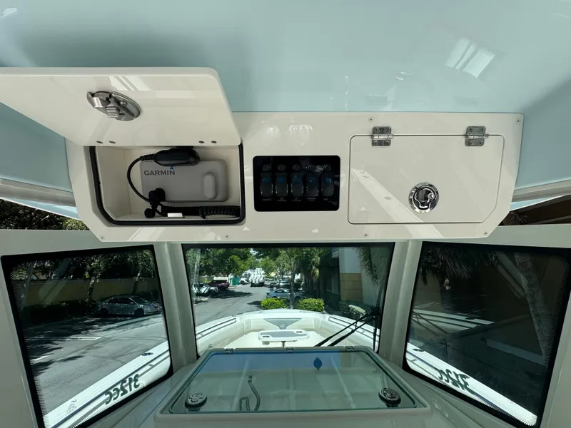 Slide: The Image of 2026 Sailfish 312 CC boat interior with Garmin equipment and storage compartments. - 15