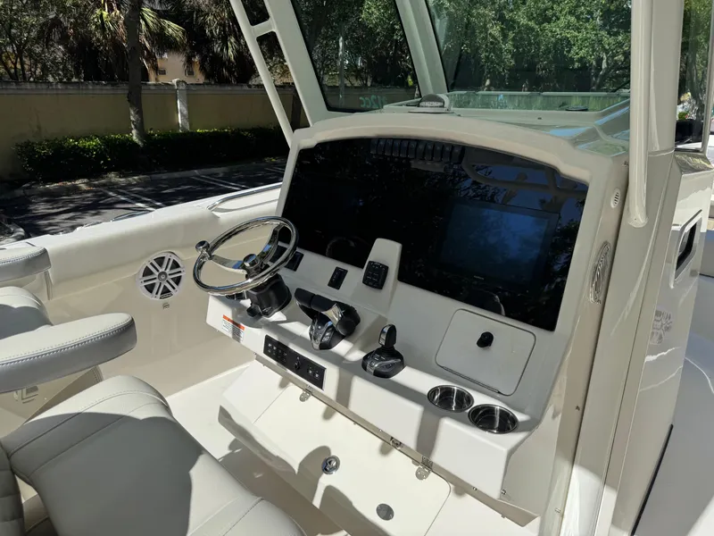 Slide: The Image of 2026 Sailfish 312 CC boat cockpit with steering wheel, controls, and seating. - 18