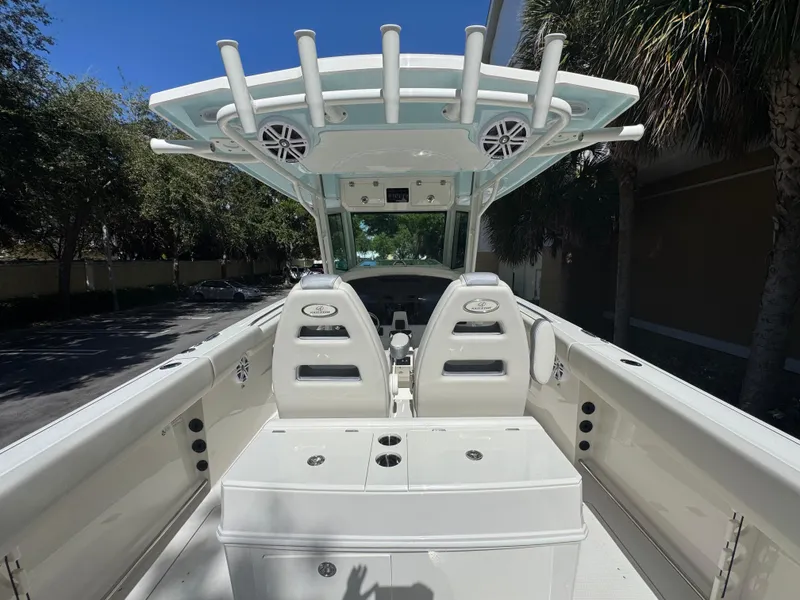 Slide: The Image of 2026 Sailfish 312 CC boat interior with seating and rod holders under a clear blue sky. - 22