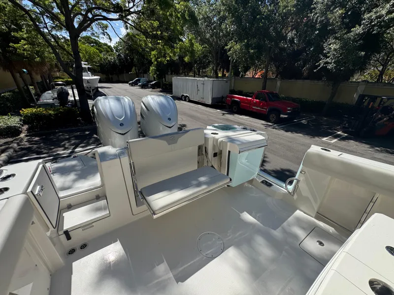 Slide: The Image of 2026 Sailfish 312 CC boat with dual engines and spacious deck in a sunny parking area. - 26