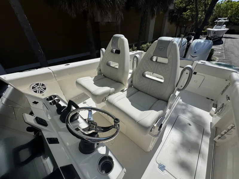 Slide: The Image of 2026 Sailfish 312 CC boat interior with dual captain's chairs and steering wheel. - 30