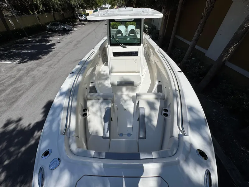 Slide: The Image of 2026 Sailfish 312 CC boat, spacious deck, white interior, parked outdoors. - 5