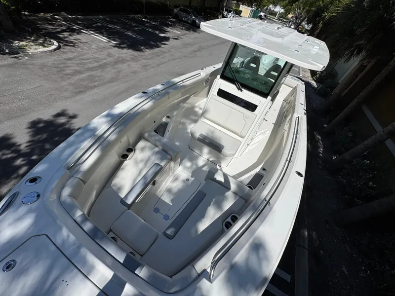 Slide: The Image of 2026 Sailfish 312 CC boat with spacious deck and seating, parked under trees. - 6
