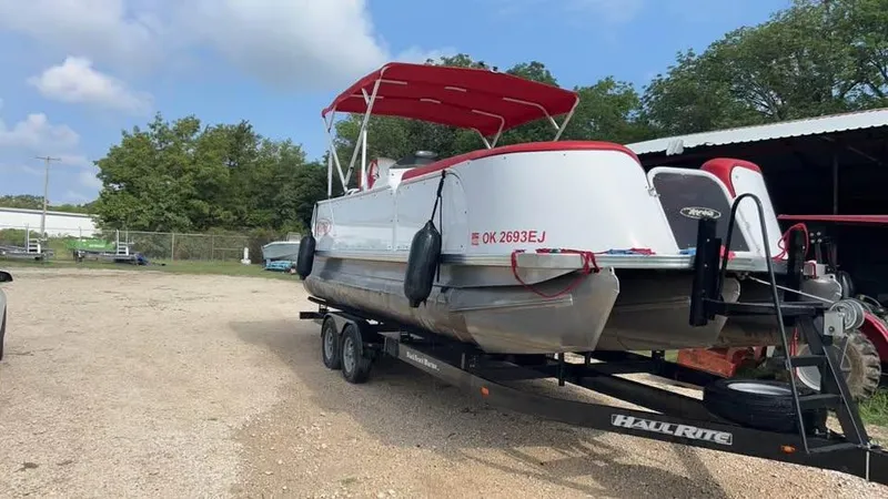 Slide: The Image of 2020 Aloha Tropical Series 230 pontoon boat on trailer, red canopy, parked outdoors. - 8