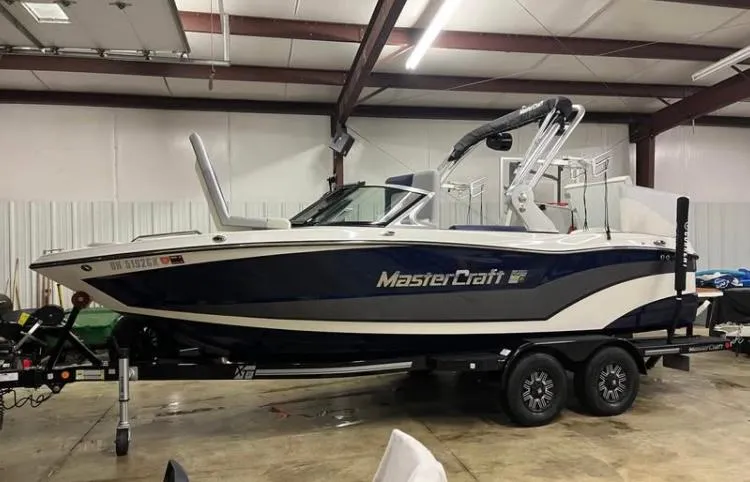 Slide: The Image of 2018 MasterCraft XT21 boat on trailer in indoor storage facility. - 1