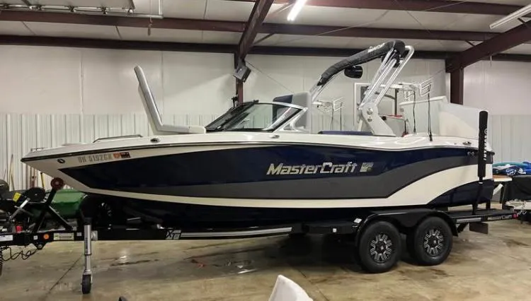 Slide: The Image of 2018 MasterCraft XT21 boat on trailer in indoor storage facility. - 2