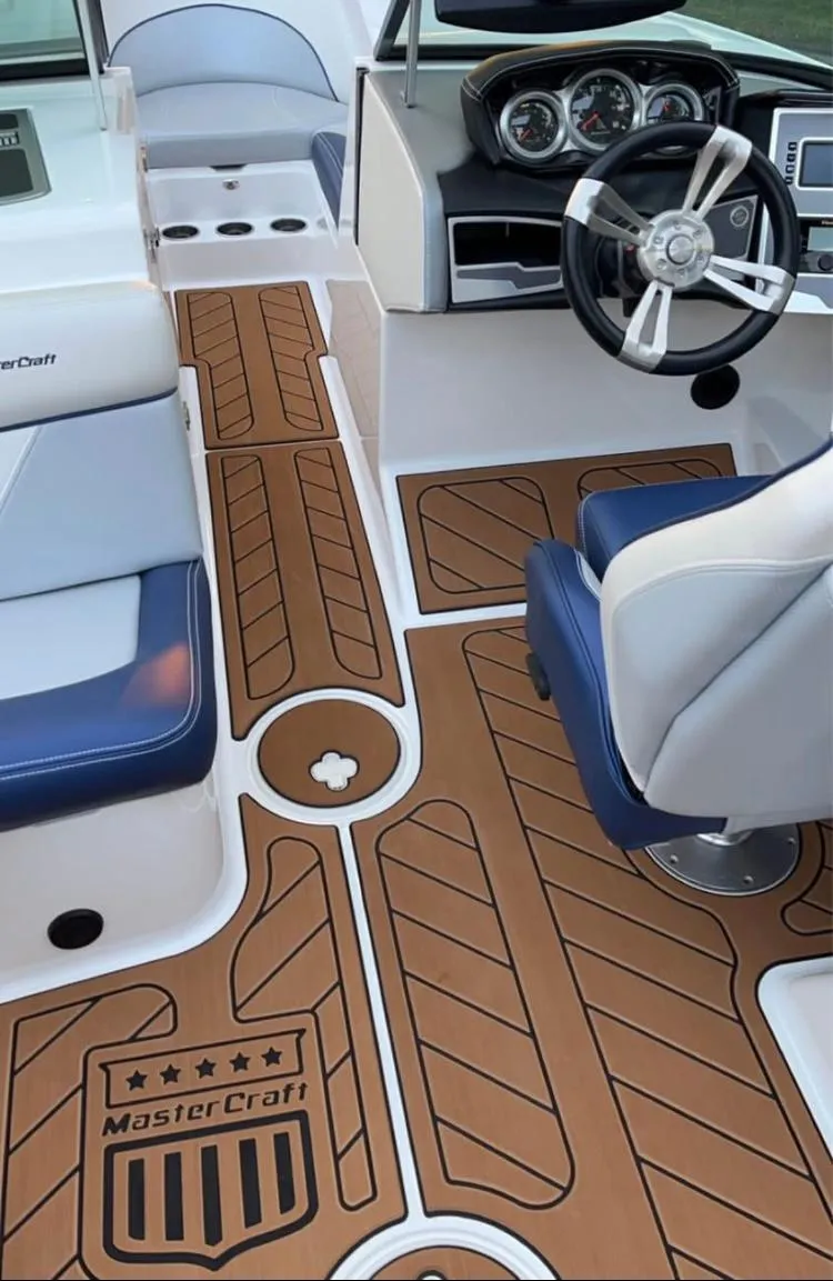 Slide: The Image of 2018 MasterCraft XT21 boat interior with stylish brown flooring and modern dashboard. - 5