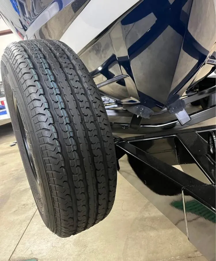 Slide: The Image of 2018 MasterCraft XT21 boat trailer tire close-up in a garage setting. - 8