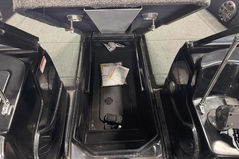 Slide: The Image of Open storage compartment in a 2020 Nitro ZV19 Sport boat, showing documents and equipment. - 21