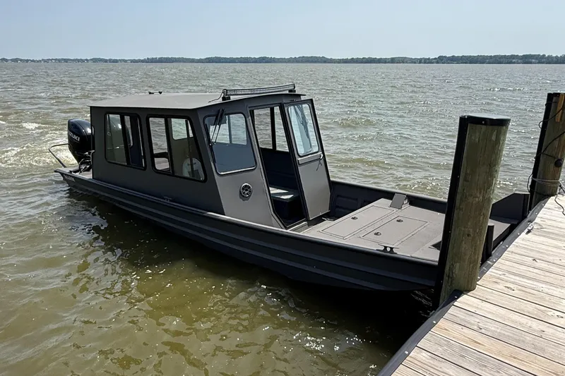 Slide: The Image of 2025 SeaArk 2672 Workhorse boat docked on a lake, featuring a sturdy design. - 3