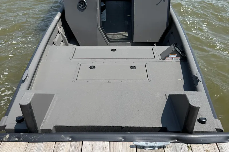 Slide: The Image of 2025 SeaArk 2672 Workhorse boat deck, gray finish, docked on water. - 5