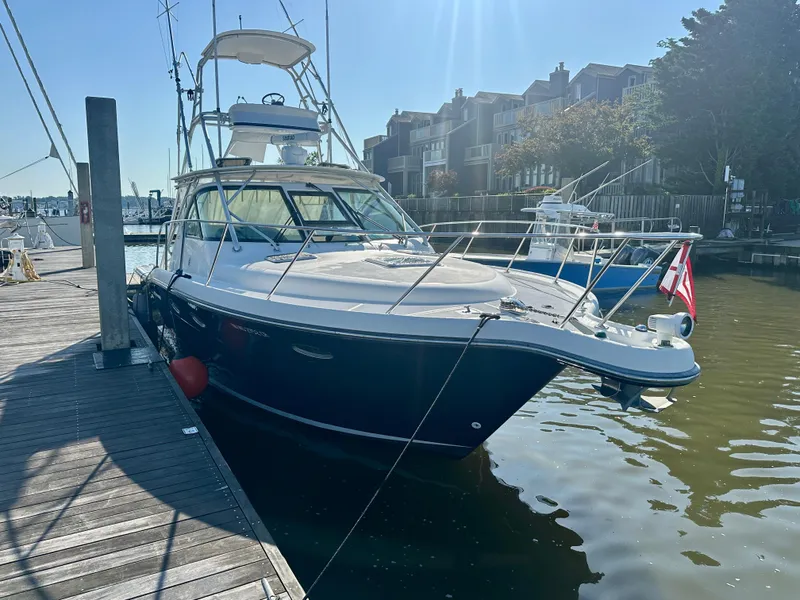 Slide: The Image of 2004 Tiara Yachts 3200 Open docked at marina, sunny day, waterfront buildings in background. - 1