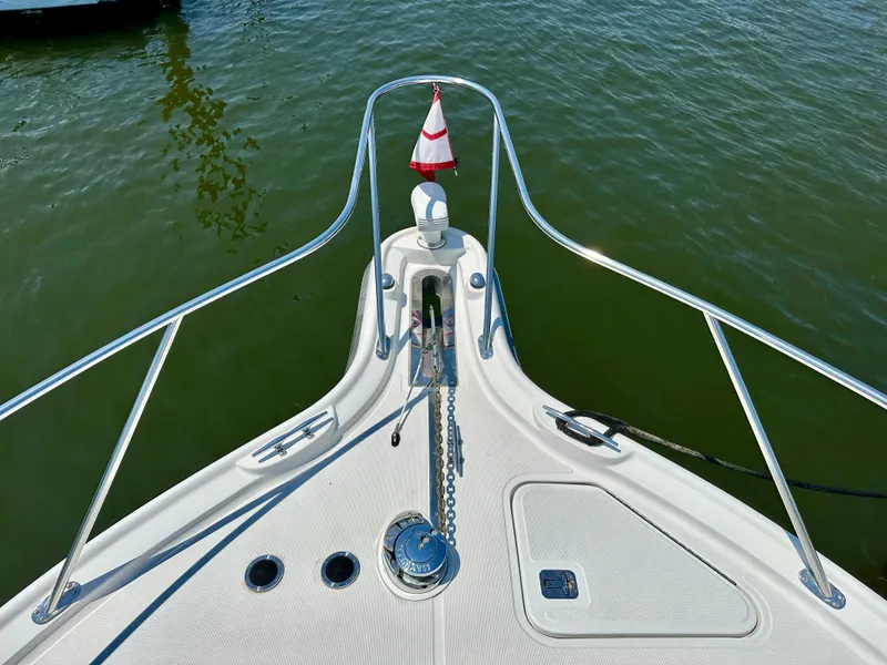 Slide: The Image of Bow of 2004 Tiara Yachts 3200 Open, featuring anchor and railing, on calm water. - 11