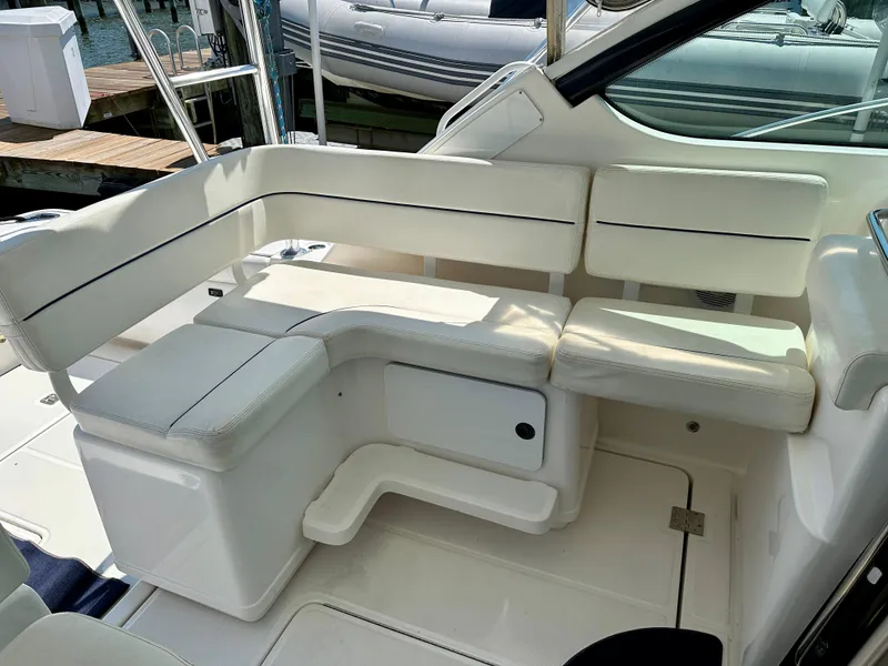 Slide: The Image of 2004 Tiara Yachts 3200 Open interior seating area with white cushioned seats. - 13
