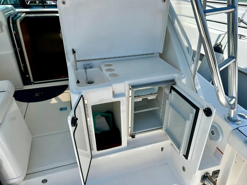 Slide: The Image of 2004 Tiara Yachts 3200 Open boat interior with open storage and mini fridge. - 14