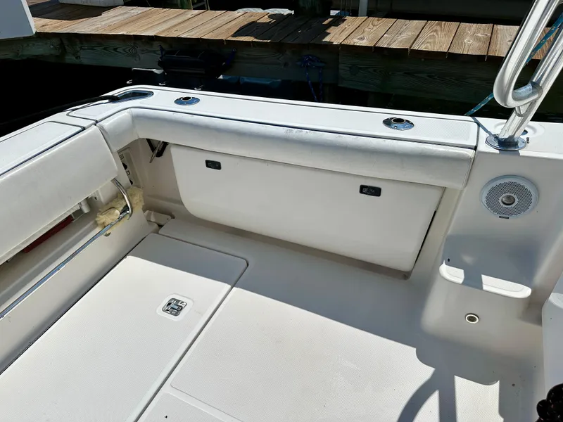 Slide: The Image of 2004 Tiara Yachts 3200 Open boat interior with seating and speaker, docked by wooden pier. - 16