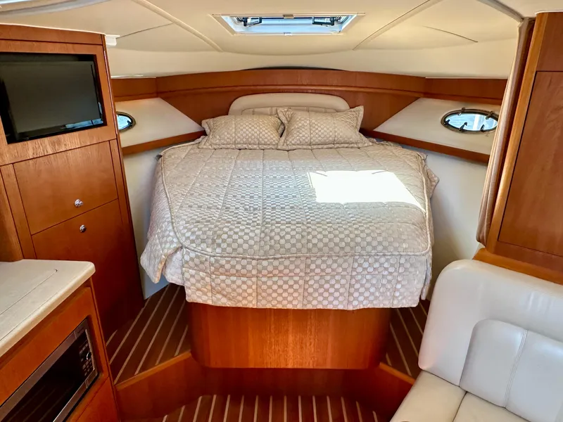 Slide: The Image of Luxurious cabin interior of 2004 Tiara Yachts 3200 Open with cozy bed and wood finish. - 19