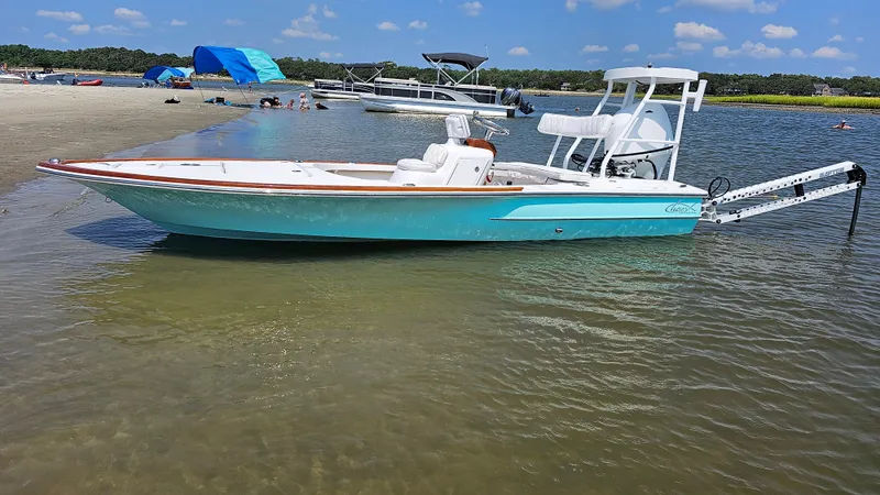 Slide: The Image of 2025 Chaos 16 Bonefish boat in shallow water near a sandy beach. - 0