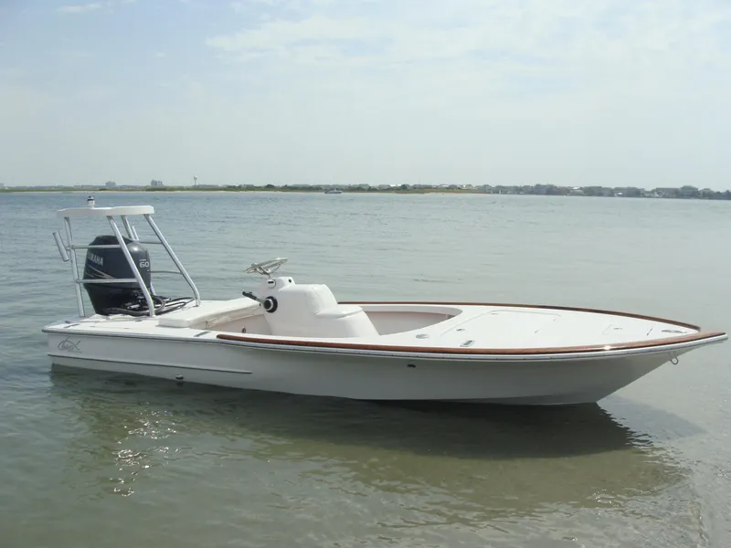 Slide: The Image of 2025 Chaos 16 Bonefish boat on calm water, featuring sleek design and modern outboard motor. - 1