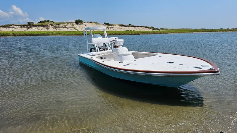 Slide: The Image of 2025 Chaos 16 Bonefish boat in shallow water near sandy shoreline. - 2