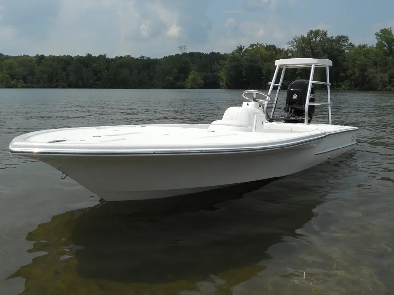 Slide: The Image of 2025 Chaos 16 Bonefish boat on calm lake with forested background. - 3