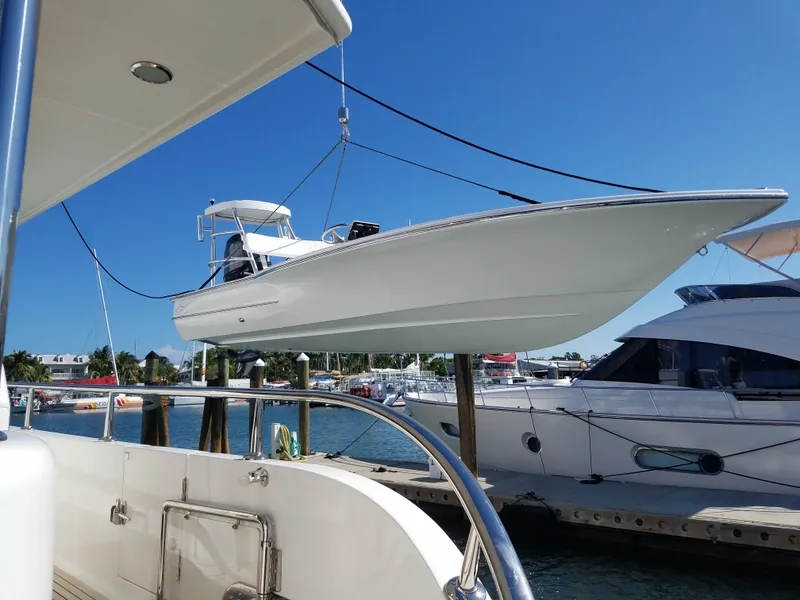 Slide: The Image of 2025 Chaos 16 Bonefish boat suspended at marina, clear blue sky background. - 6