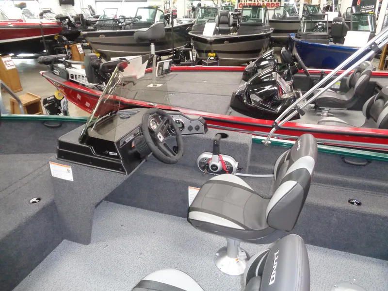 Slide: The Image of 2025 Lund 1650 Rebel XL SS boat interior with steering console and seating in showroom. - 12